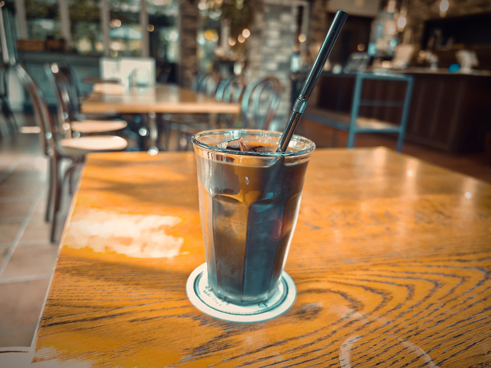 カフェ イレブンシス ティールームス：堀口珈琲の豆を使ったアイスコーヒー。うさぎのロゴ入りコースターで提供。