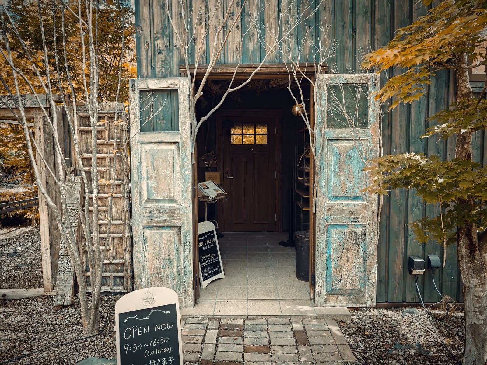 GAFLO CAFE：古材の扉が開いたカフェの入口。A看板の表示は「OPEN NOW 9:30〜16:30（L.O.16:00）」（2026年8月撮影）。