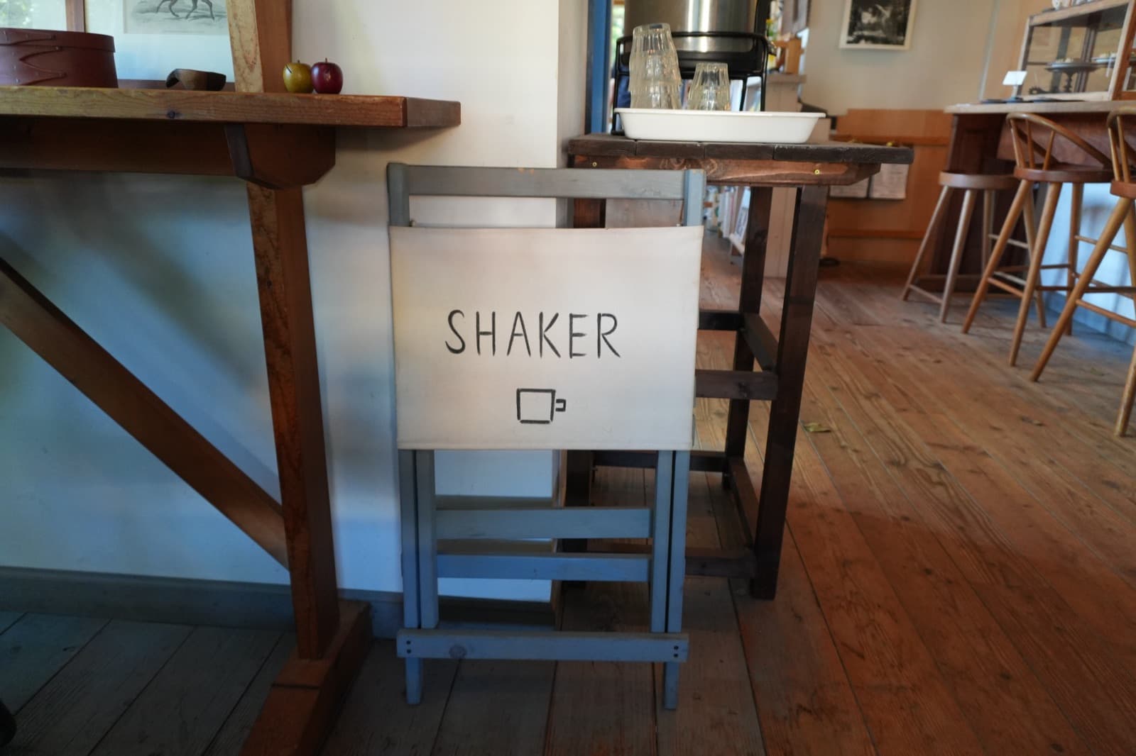 背もたれに「SHAKER」と入った手づくりの子ども用チェア。板張りの床と、奥のカウンター席が見える(2026年9月22日訪問)