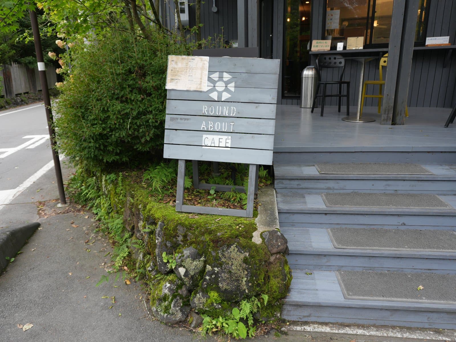 六本辻のラウンドアバウト側にある入口と、ROUND ABOUT CAFEの木の看板。看板の上に店頭メニューが貼られています(2026年9月19日・編集部撮影)